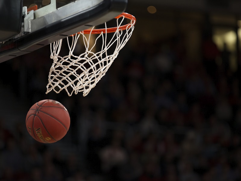 NBA季后赛中湖人队与凯尔特人队激烈对抗，詹姆斯突破上篮，球场灯光璀璨